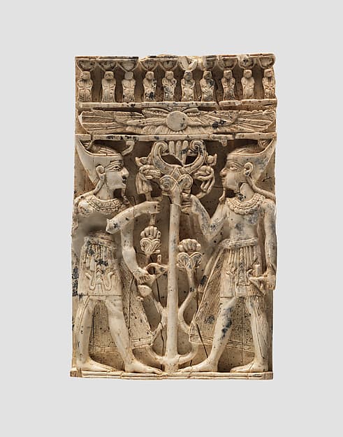 Furniture plaque carved in high relief with two Egyptianizing figures flanking a volute tree