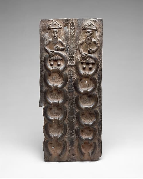 Plaque with Portuguese Traders and Manillas, by Ìgùn Ẹ́rọ̀nwwọ̀n (brass-casting guild) artists