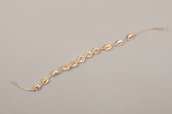 String of cowrie shell beads on fiber