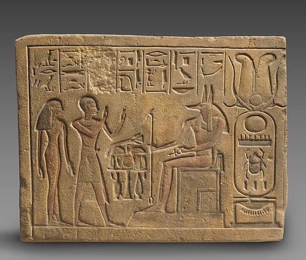 Relief showing a priest and a woman worshipping Anubis