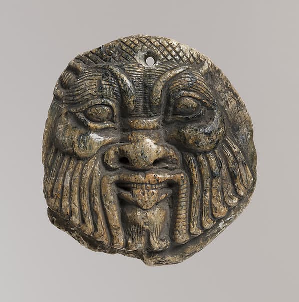 Bes head disk with scene of Isis and Horus in marsh on reverse