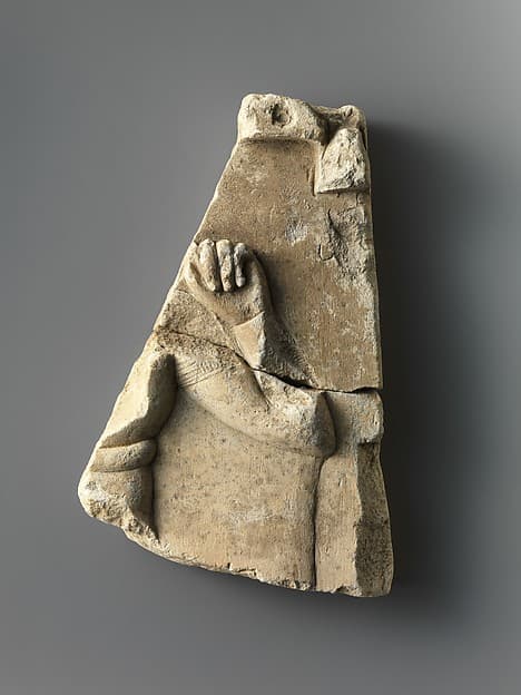 Fragment of relief plaque with a child god, inscribed on reverse