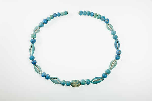 String of ball beads, cowrie-styled beads, and a scarab