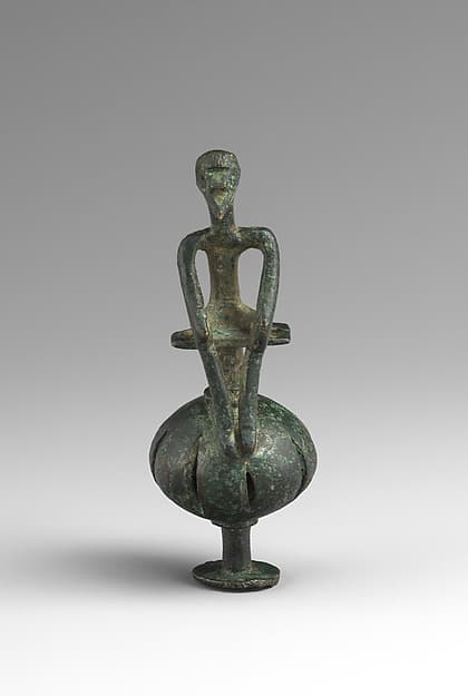 Bronze man seated on a ball