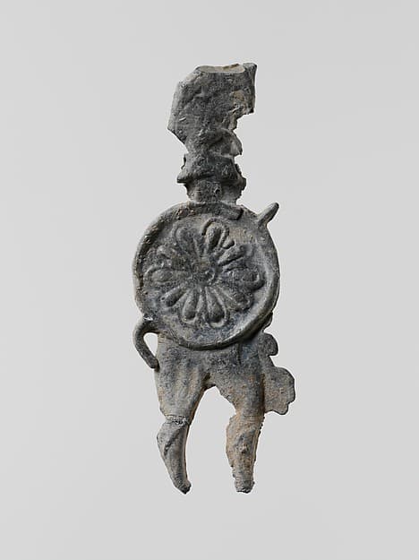 Lead figure of a warrior with a helmet, shield, and spear