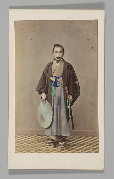 [Japanese Naval Officer] [Studio Portrait: Japanese Man (Tateise Onogero) Standing Holding Hat and Sword], by Felice Beato