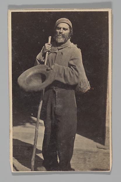 [Studio Portrait: Man with Walking Stick Begging (?)], by Le Vot