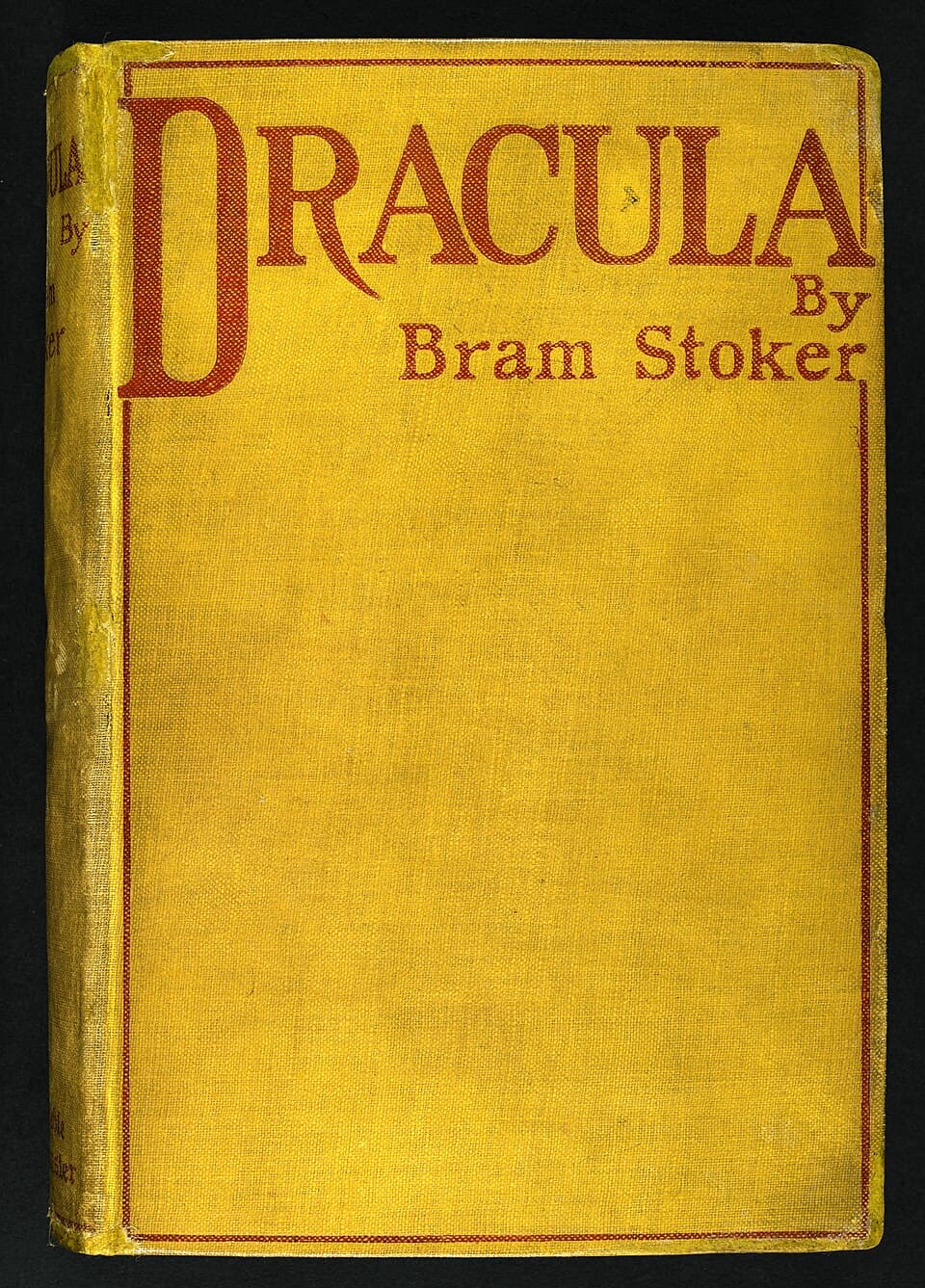 The mustard-yellow cloth cover of the 1897 first edition of Dracula, with the title and author’s name stamped in red.