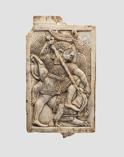 Furniture plaque carved in relief with a male figure slaying a griffin