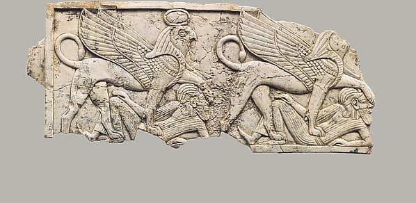 Furniture plaque carved in relief with two falcon-headed sphinxes trampling captives
