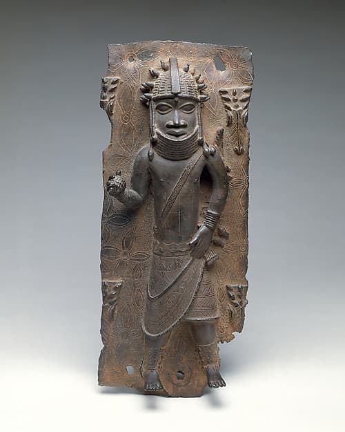 Plaque with Court Official Holding a Protective Rattle, by Ìgùn Ẹ́rọ̀nwwọ̀n (brass-casting guild) artists