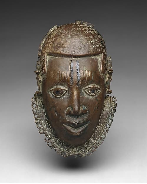Pectoral ornament with face, by Ìgùn Ẹ́rọ̀nwwọ̀n (brass-casting guild) artists