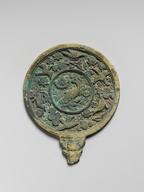 Mirror with handle and decorated with peacock, flowers, and birds