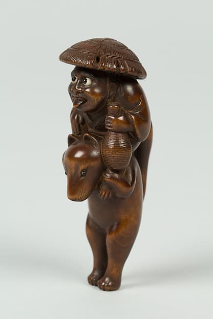 Netsuke of Boy Sitting on the Shoulders of an Animal