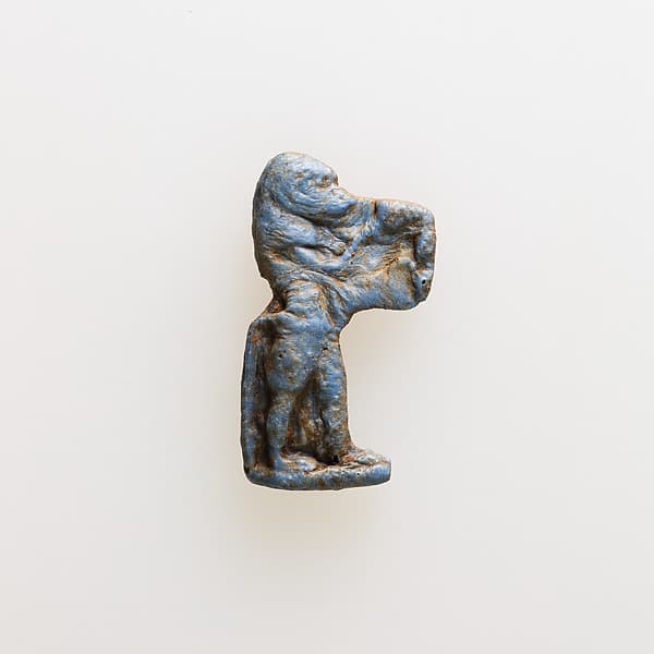 Amulet of a baboon holding an unrecognizable object