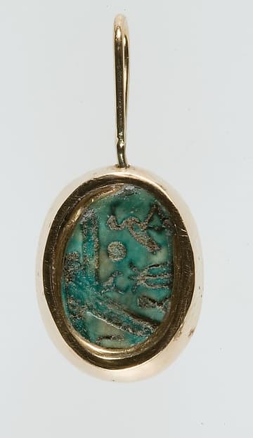 A modern pendant setting holding an inscribed scarab