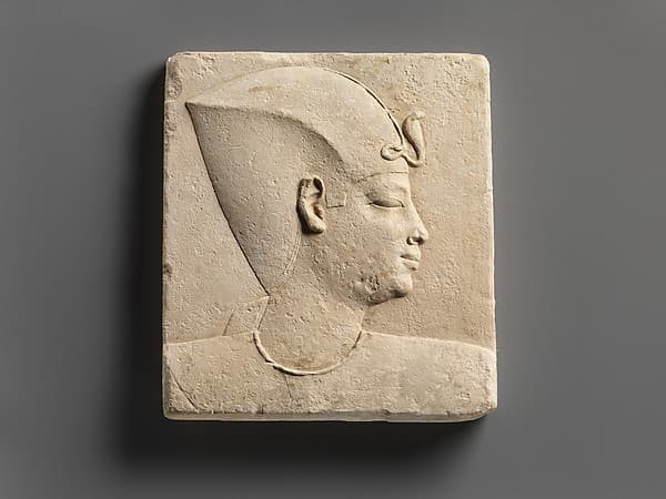 Relief of king's head in blue crown, head of child god on opposite side