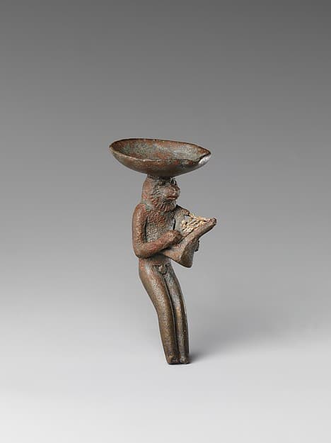 Monkey playing the lyre and carrying a dish on its head