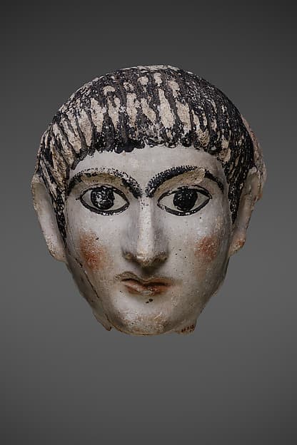 Mask of a man with hair combed forward and a mantle