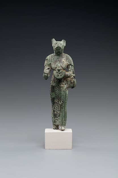 Bastet holding a lion-headed aegis, a sistrum (broken), and a basket