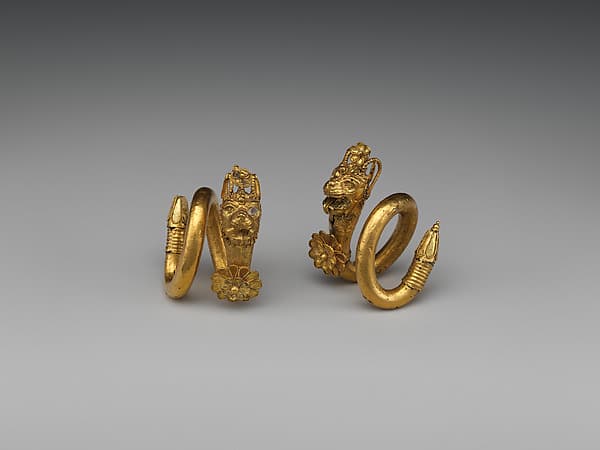 Gold and copper alloy spiral earring with lion-griffin head terminal