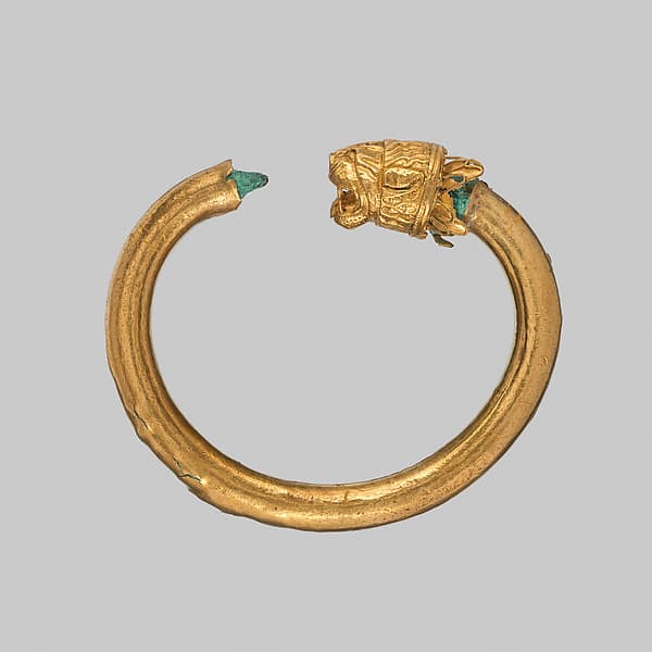Gold and copper alloy bracelet with lion-head finials