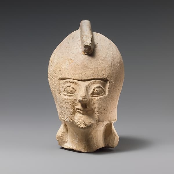 Limestone head of a warrior wearing a crested helmet