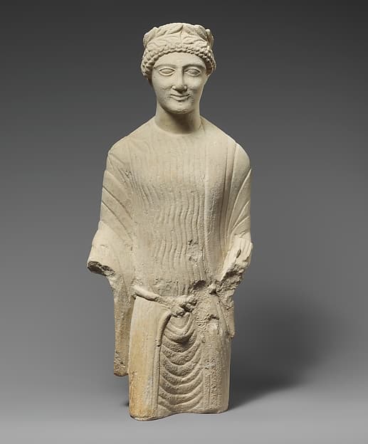 Limestone statuette of a beardless male votary with a wreath of leaves