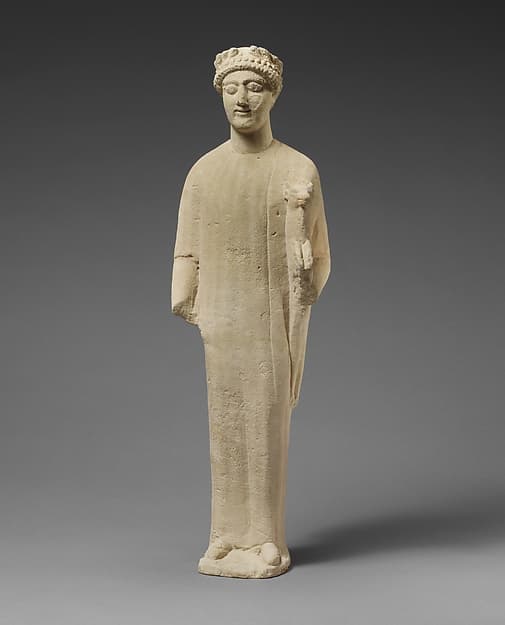 Limestone statuette of a beardless male votary with a wreath of leaves