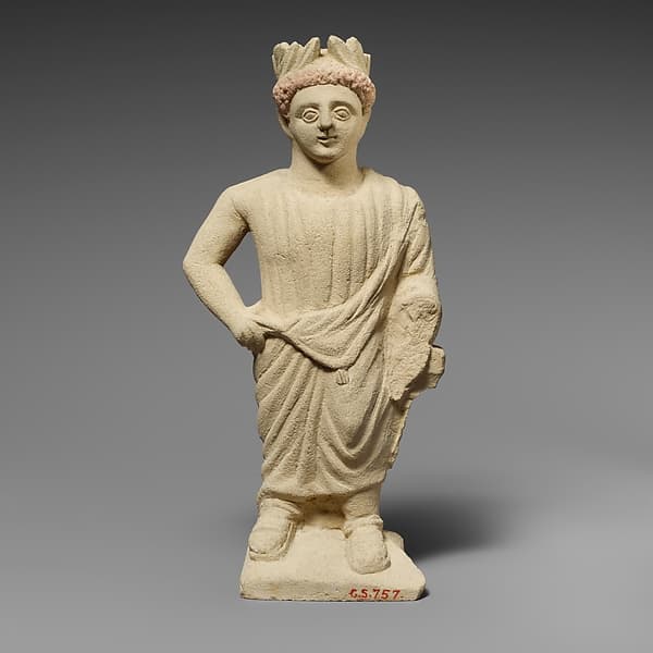 Limestone statuette of a beardless male votary with a wreath of leaves