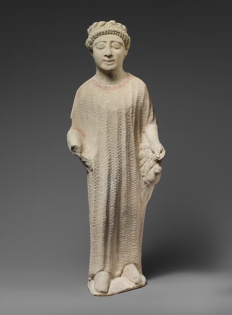 Limestone statuette of a boy holding a dove