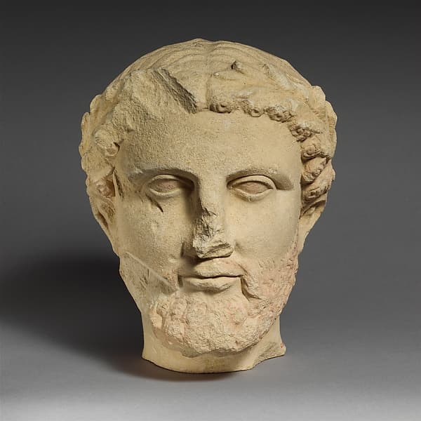 Limestone bearded head with a wreath of leaves