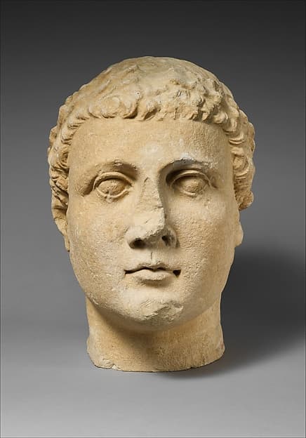 Limestone head of beardless male votary
