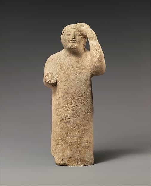 Limestone figure holding a mask