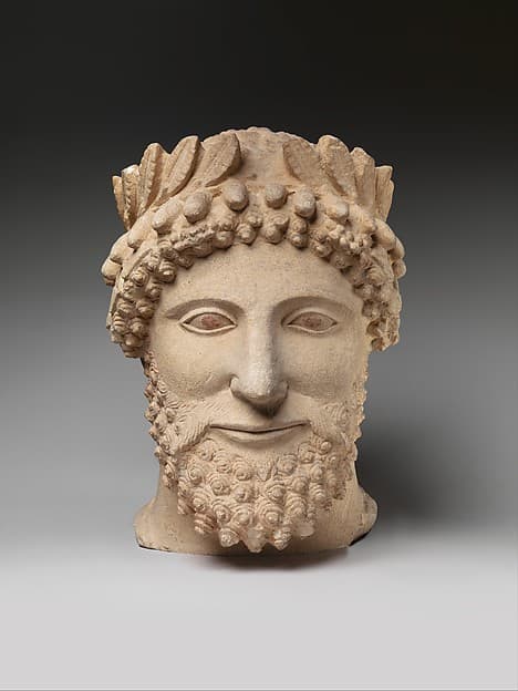 Limestone head of a bearded man wearing a wreath