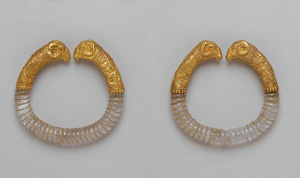 Pair of bracelets with rock crystal hoops and gold rams' heads